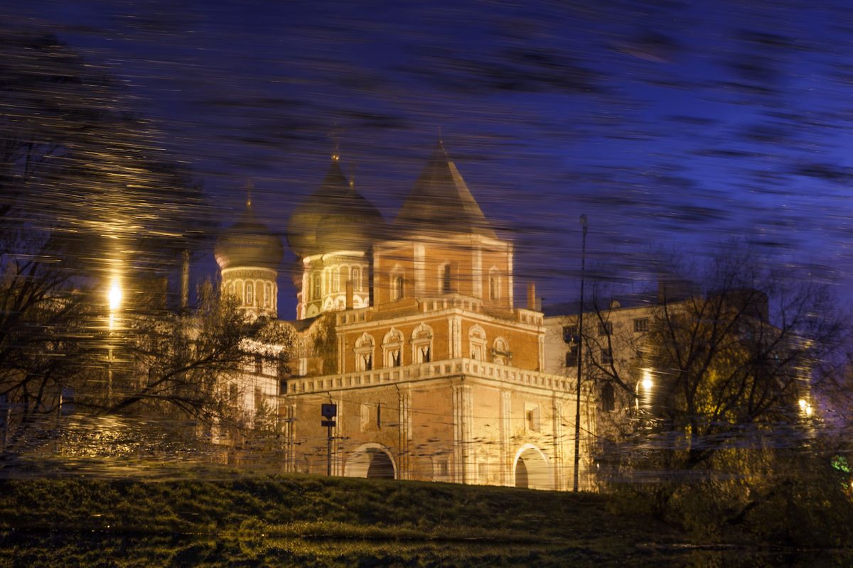 Manor Izmailovo, Bridge Tower, and Intercession Cathedral. Reflection in the water of the pond with autumn leaves. long time exposure