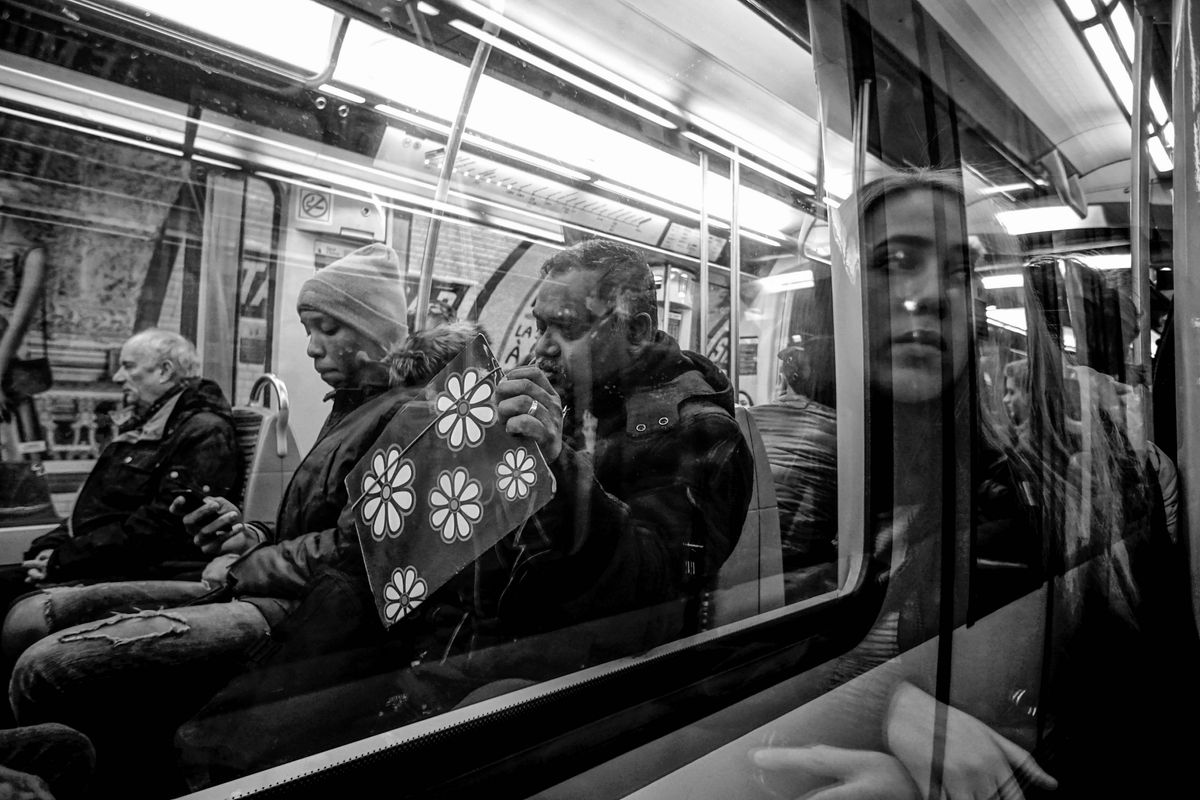 Deux voitures de voyageurs se croisent. Un sac à fleurs, le reflet d'une femme, chacun regarde ailleurs.