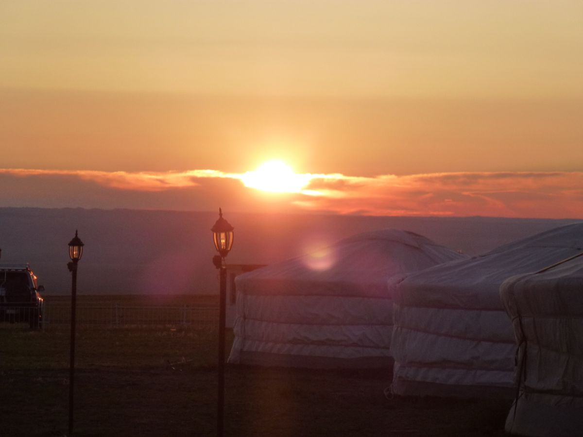 Sonnenaufgang über Jurtencamp in der Mongolei